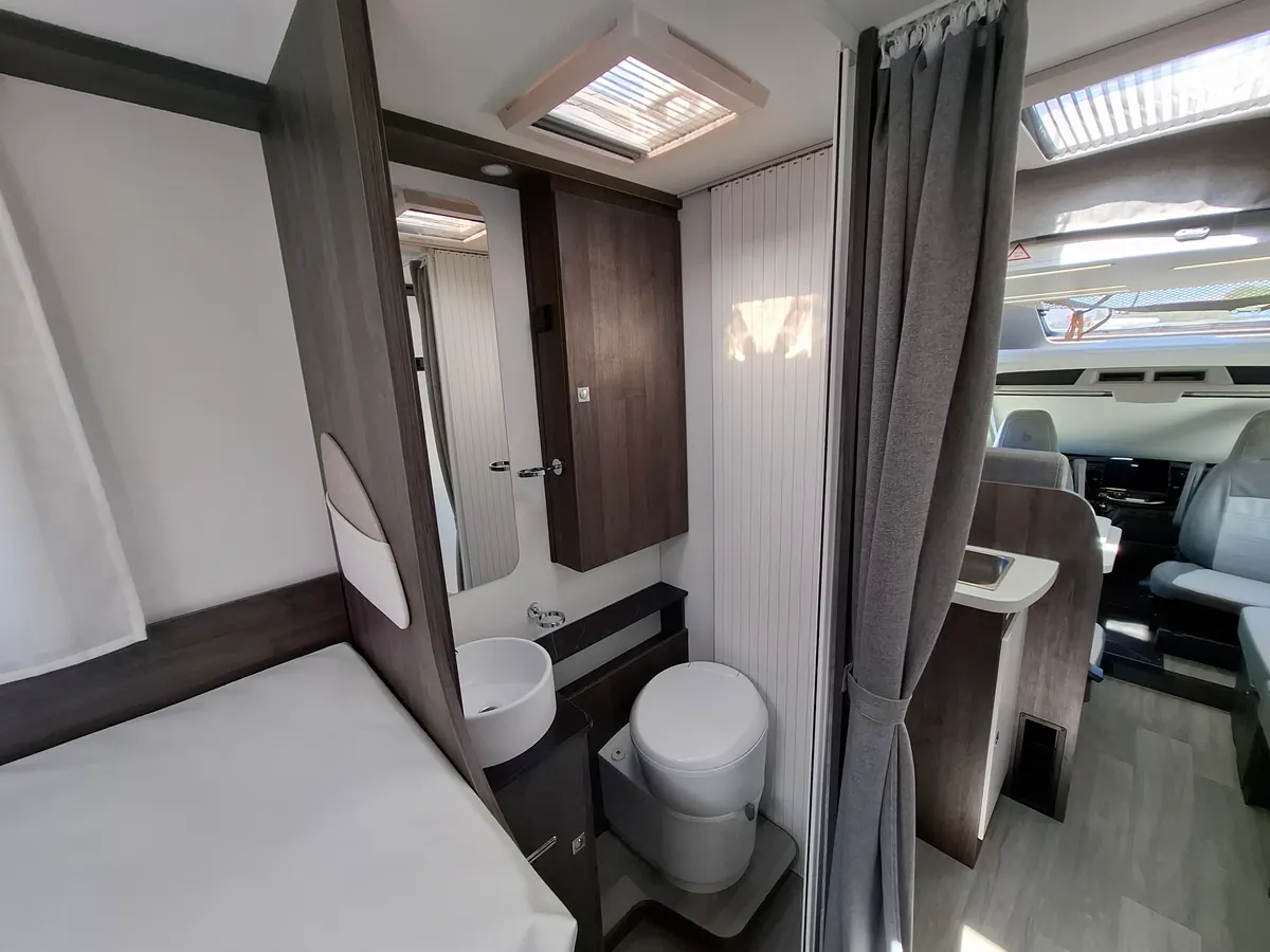 Baño de la autocaravana perfilada con lavabo, inodoro y espejo
